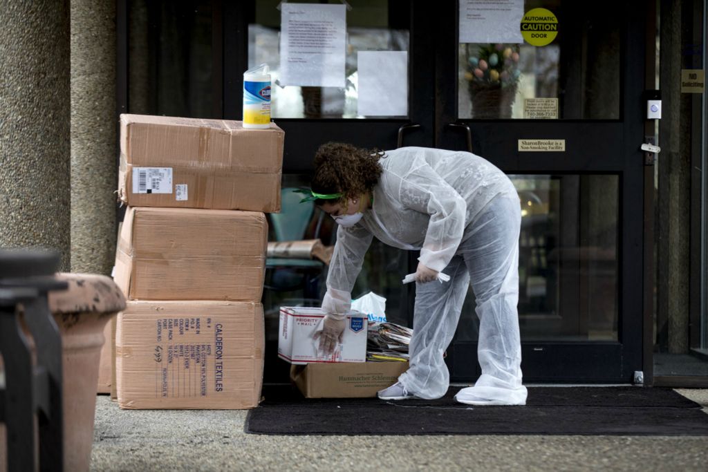 Third Place, Feature Picture Story - Jessica Phelps / Newark Advocate, “Nurses Go On Lockdown With Residents”Elizabeth Johnson disinfects every package that is left outside SharonBrooke in March, 2020 before bringing it inside. This is to kill any possible virus that is left on the items. Johnson has been working at SharonBrooke for 5 years. She with other staff members of the senior living residence voluntarily put herself on lockdown, deciding not to leave the building for weeks as a measure to help keep the residents safe. "This is my family too," she said. "It's these people' lives and I'm here to keep them healthy and safe."